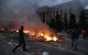 A protester walks past a burning pro-Russian tent camp near the trade union building in Odessa